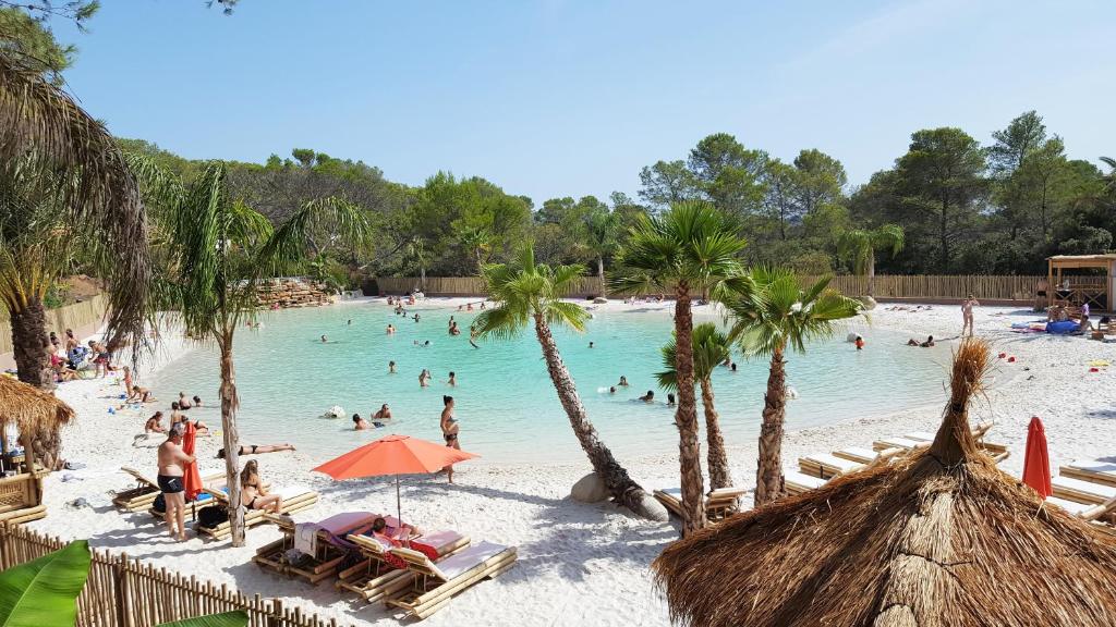 un groupe de personnes dans l'eau d'une plage dans l'établissement Carazur Mobilhomes Camping Fréjus, à Fréjus