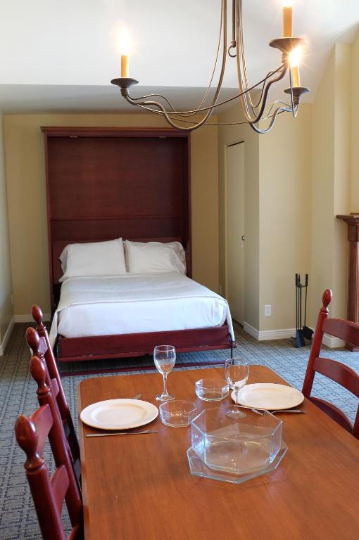 a dining room table with two chairs and a bed at Place Saint Bernard Mont Tremblant in Mont-Tremblant
