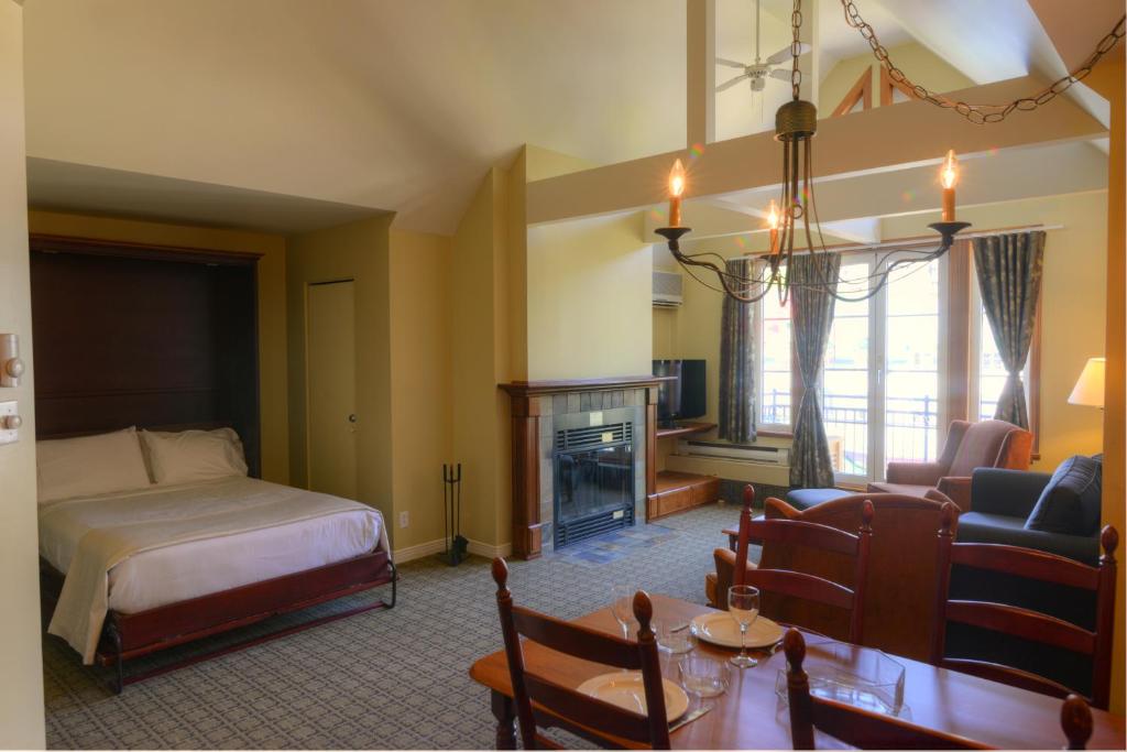 a bedroom with a bed and a living room at Place Saint Bernard Mont Tremblant in Mont-Tremblant