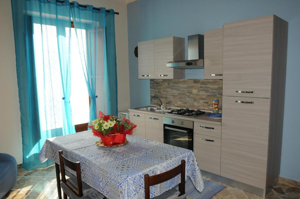 a kitchen with a table with a vase of flowers on it at CASA CALISI in Terrasini