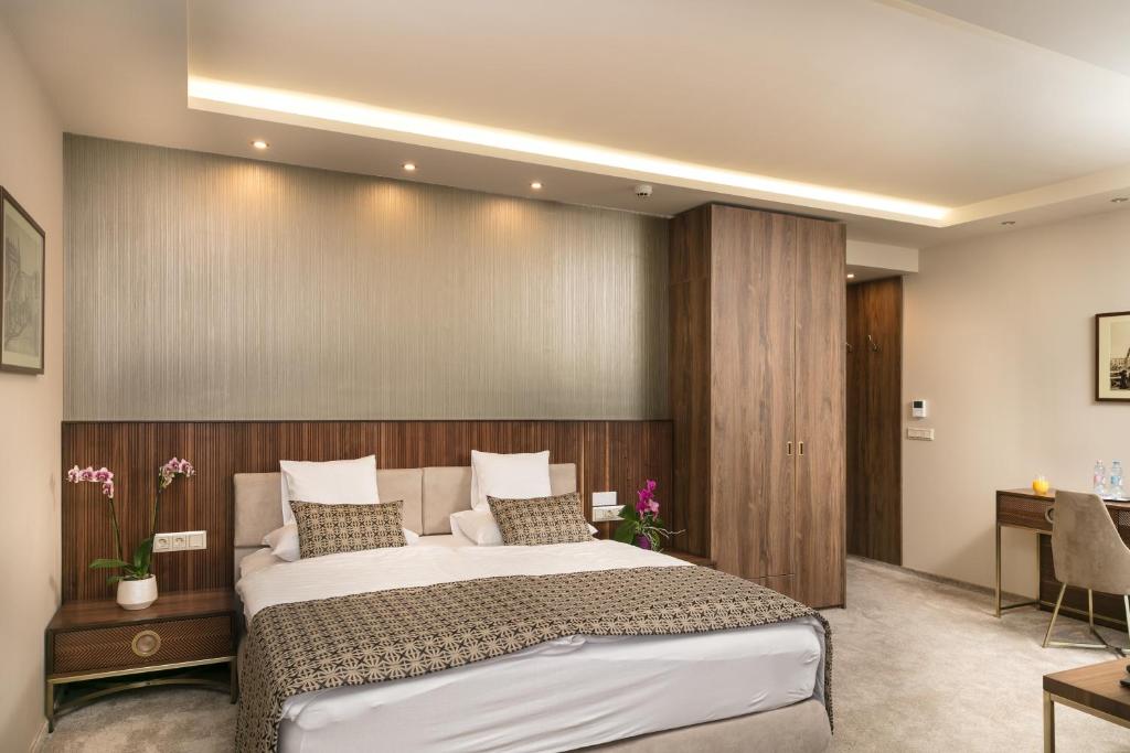 a bedroom with a large bed with a wooden wall at Hotel Kálvária Superior in Győr