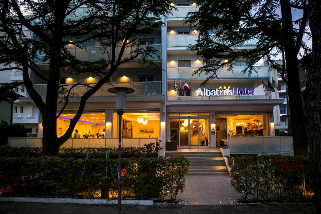 Hotel Albatros في ليدو دي يسولو: اطلالة ليلية على عمارة سكنية مع لافتة مضاءة