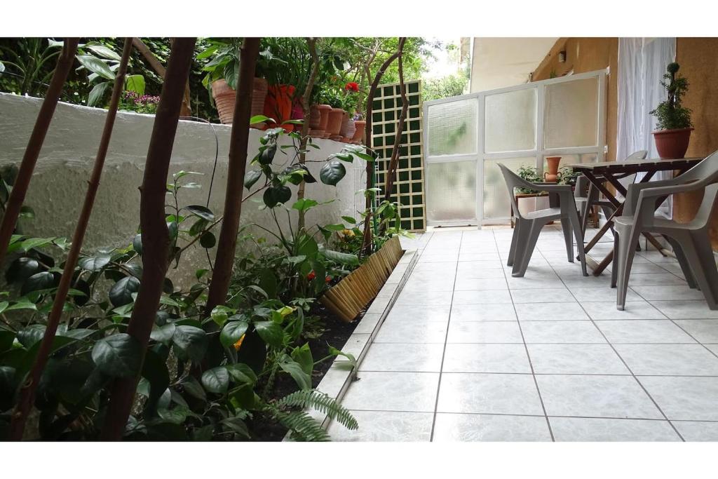 a patio with a table and chairs and plants at Athens, Cholargos metro appartment (1 to 6 persons) in Athens