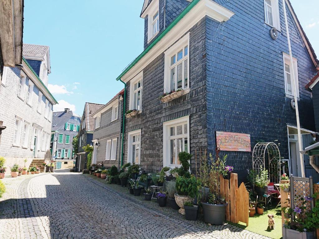 a cobblestone street in front of a blue building at Quermalerei in Remscheid