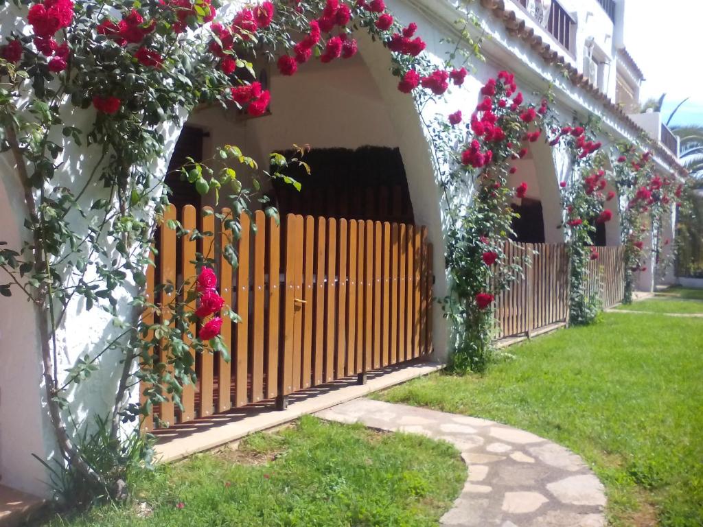 a wooden gate with flowers on a house at Apartamentos Alcossebre "El Faro Apartaments Alcossebre" Piscina, Playa y diversión in Alcossebre