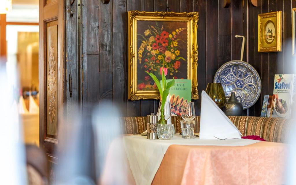una mesa con un jarrón de flores encima en Hotel Post Hönigwirt en Kirchschlag