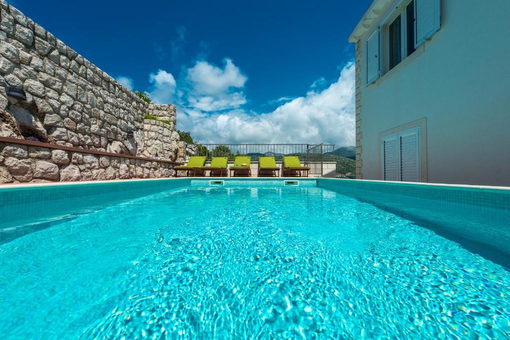 - une piscine d'eau bleue en face d'un bâtiment dans l'établissement Penthouse Leon, à Dubrovnik