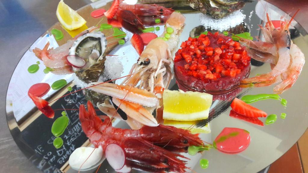 a plate of food with seafood on a table at Luna Convento Copanello B&B in Stalettì