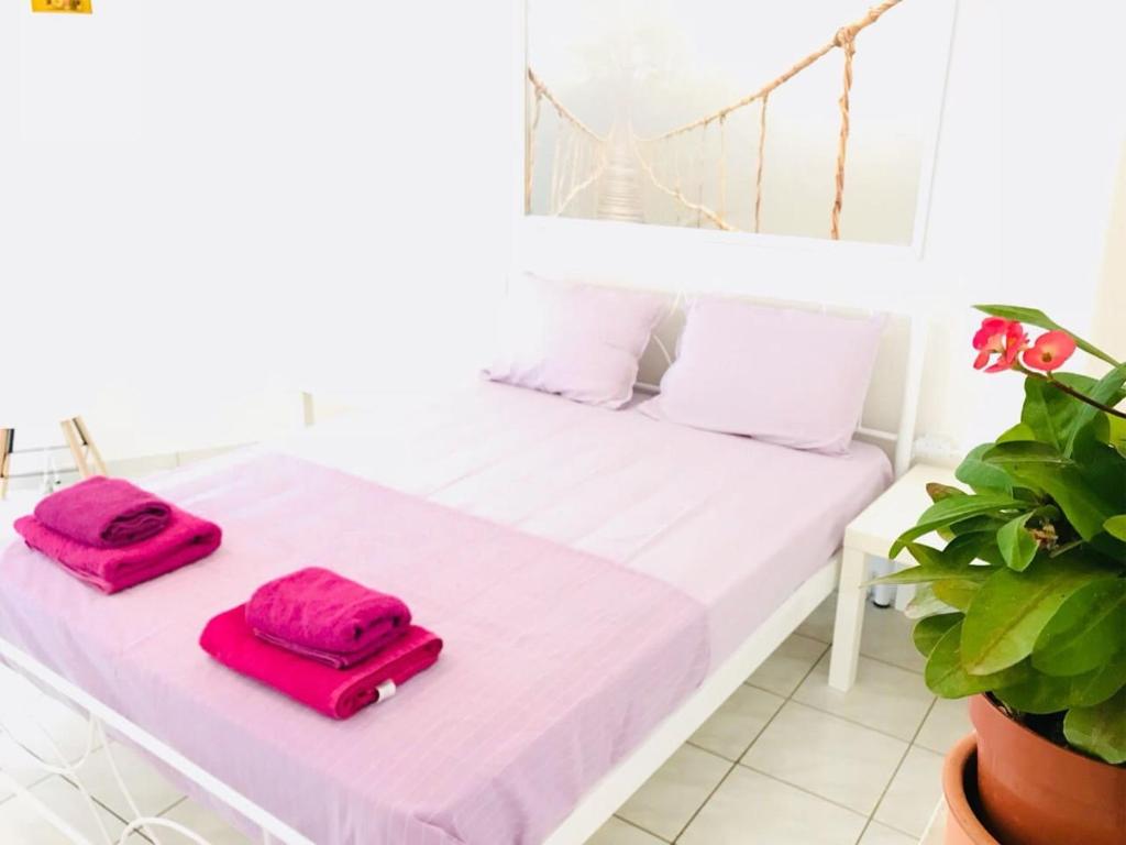 dwie czerwone torby siedzące na białym łóżku w obiekcie Korona beach apartments IIIΙ w Retimnie