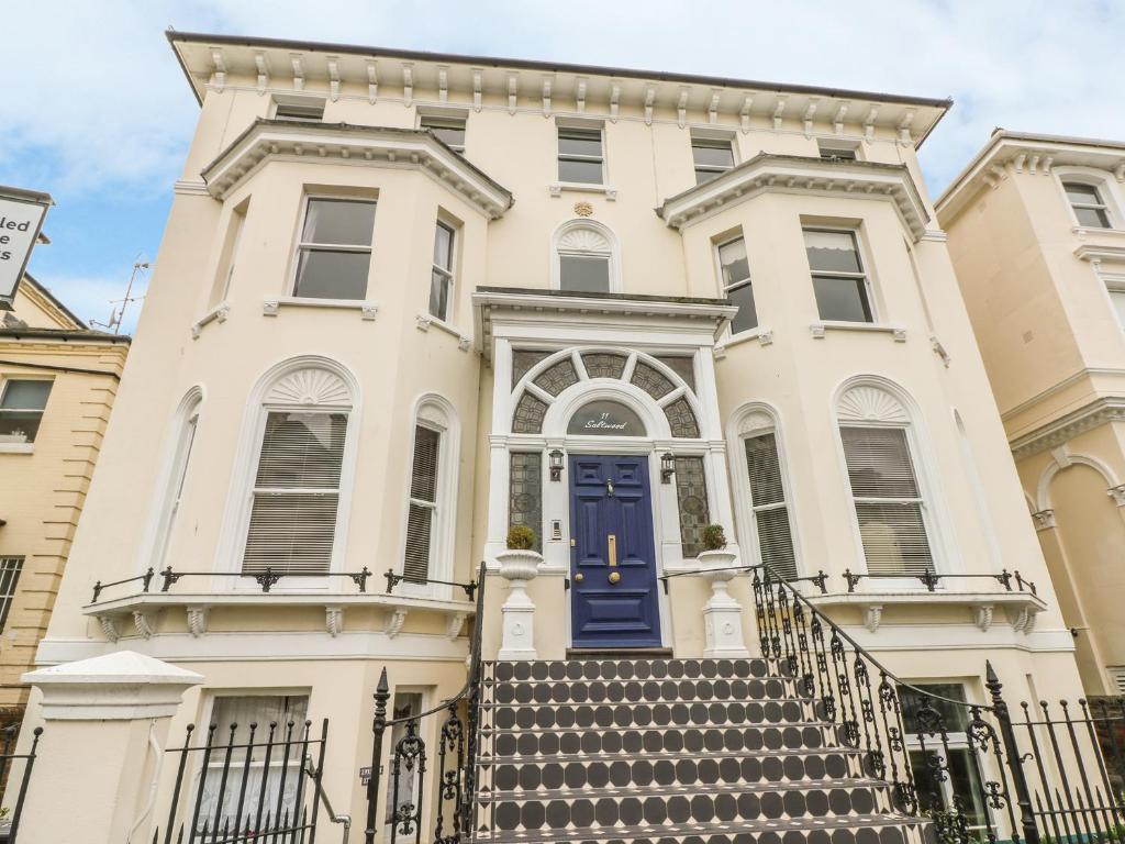 una grande casa bianca con una porta blu di Saltwood a Eastbourne