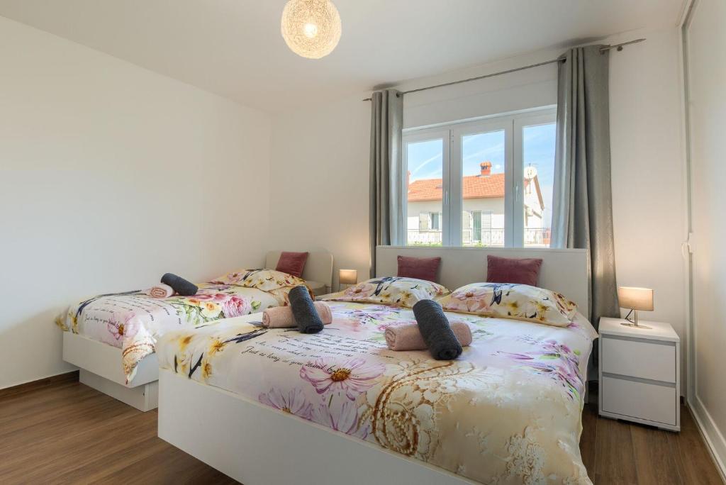 1 dormitorio con 2 camas y ventana en Esther Apartment en Pula