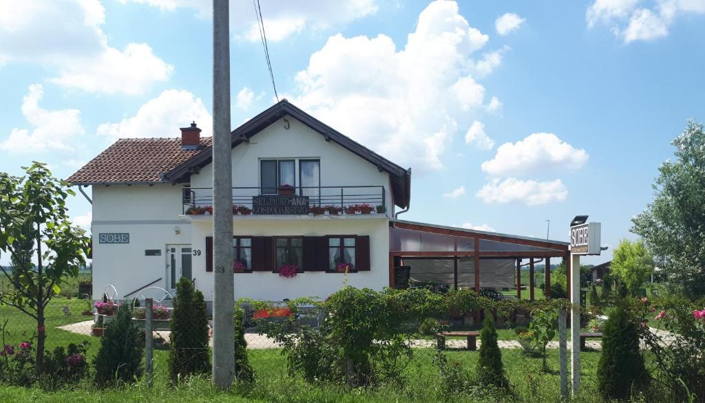 Una casa blanca con un balcón en el lateral. en Bed & Breakfast Ana, en Švajcarnica