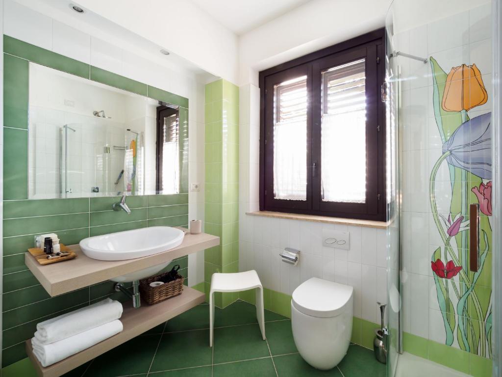 a bathroom with a sink and a toilet and a mirror at Hotel Sirius in Taormina