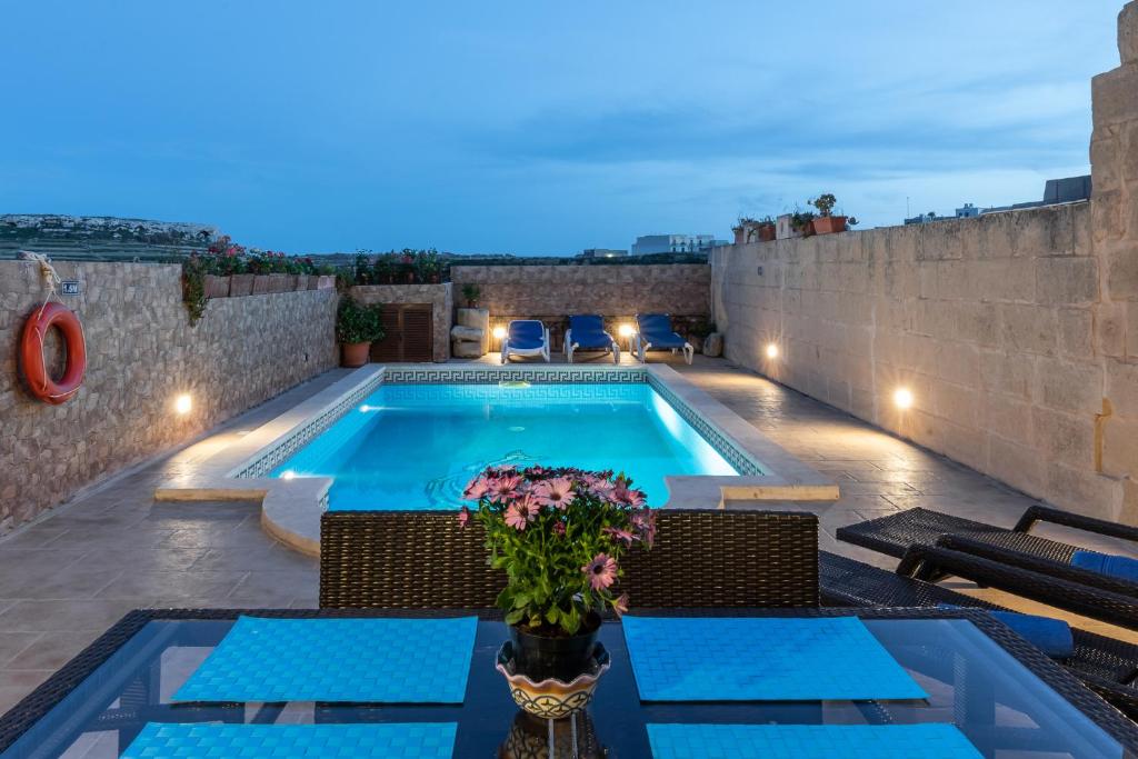 a villa with a swimming pool at night at Villayana Holiday Home in San Lawrenz