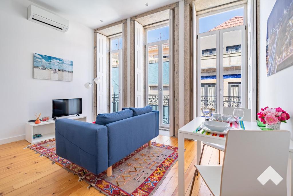 ポルトにあるBright Apartment • Downtown Portoのリビングルーム(青いソファ、テーブル付)