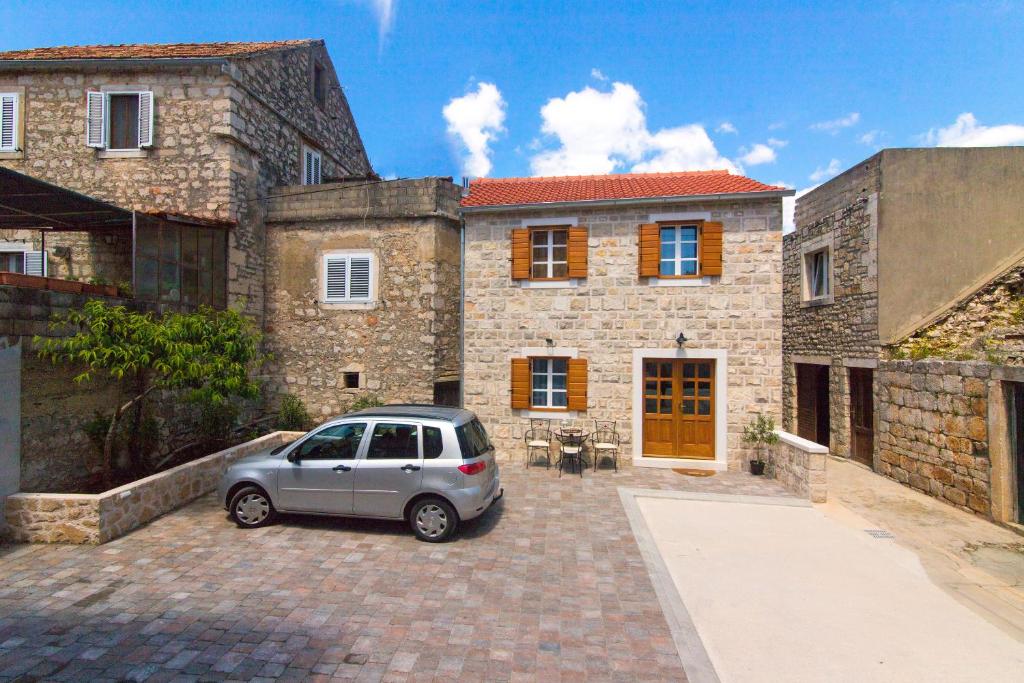 a car parked in front of a stone house at House Tia in Vrboska