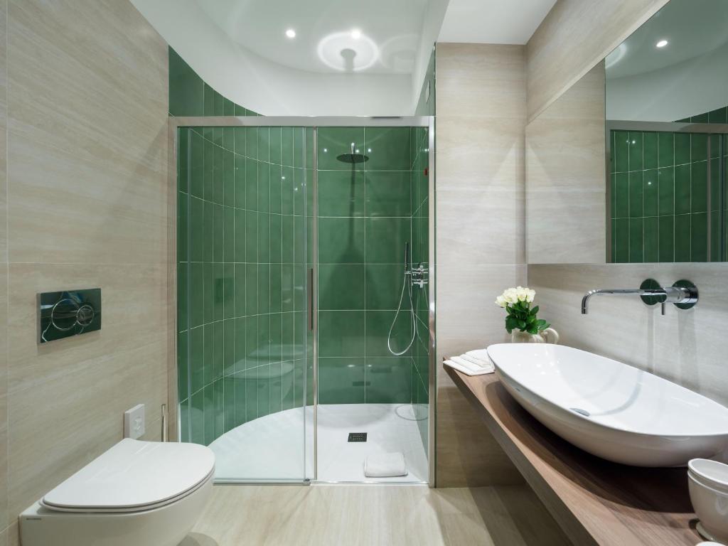 a bathroom with a shower and a toilet and a sink at Hotel Sirius in Taormina