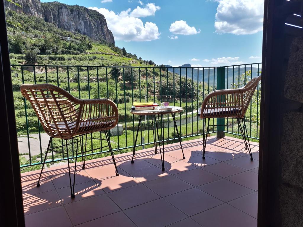 2 sillas y mesa en un balcón con vistas en B&B Taccu Maccu, en Ulassai