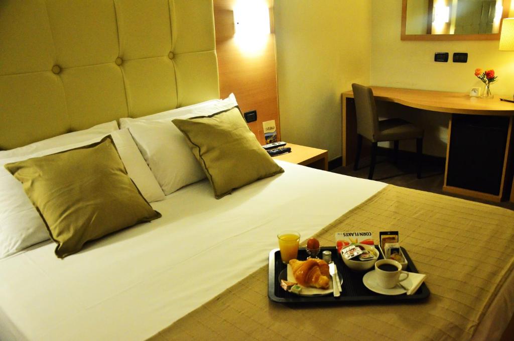 una habitación de hotel con una bandeja de comida en una cama en Residenza Cola Di Rienzo - Suite In Rome, en Roma