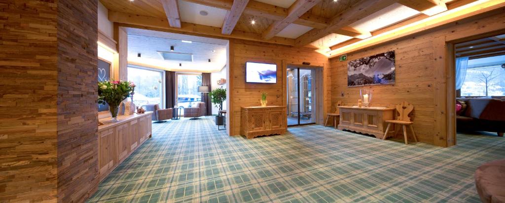 a large room with wooden walls and wooden flooring at Hotel Bergland in Pertisau