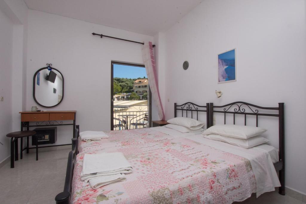 a bedroom with a bed and a table and a window at Plessas Studios in Tsilivi