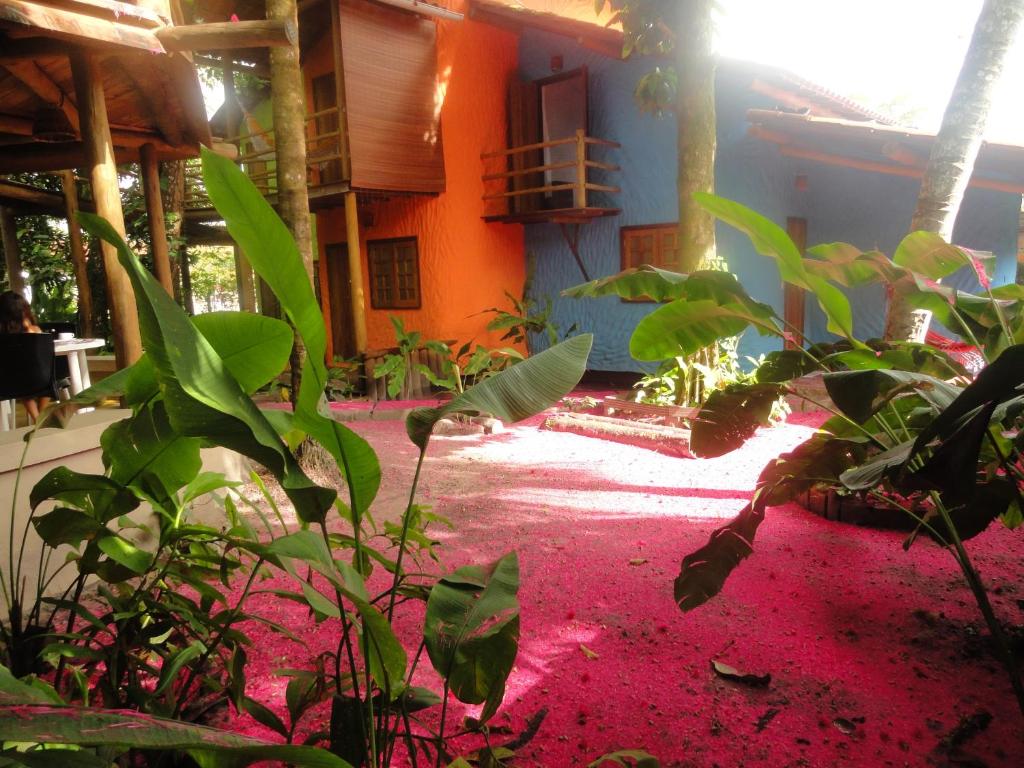 uma casa com um tapete vermelho em frente a um edifício em Pousada Aldeia na Ilha de Boipeba