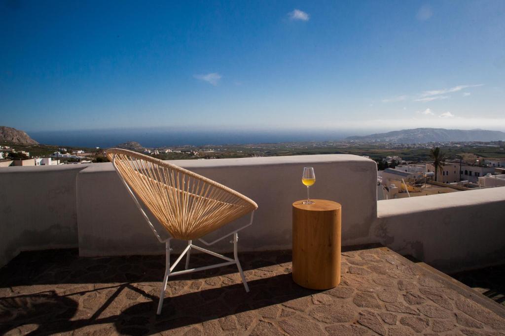 a glass of wine and a chair on a balcony at Sweet nectar villa at Pyrgos with heated jacuzzi in Pyrgos