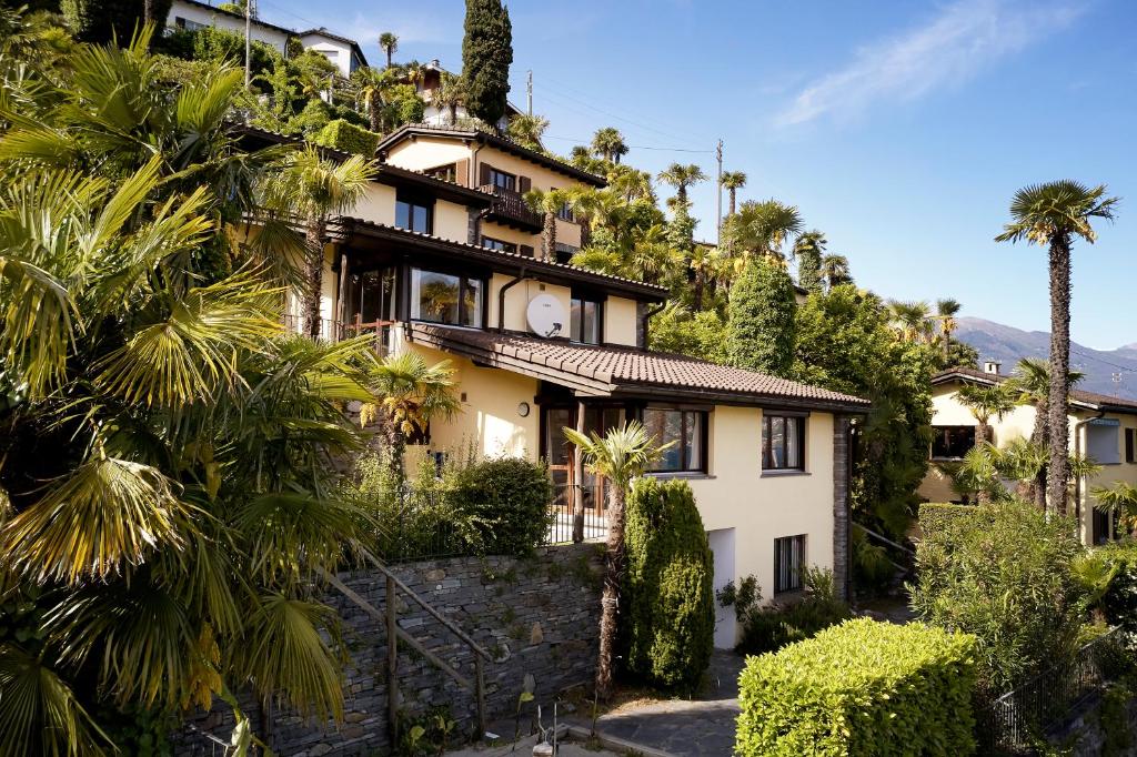 a house on a hill with palm trees at Reka-Ferienanlage Brissago in Brissago