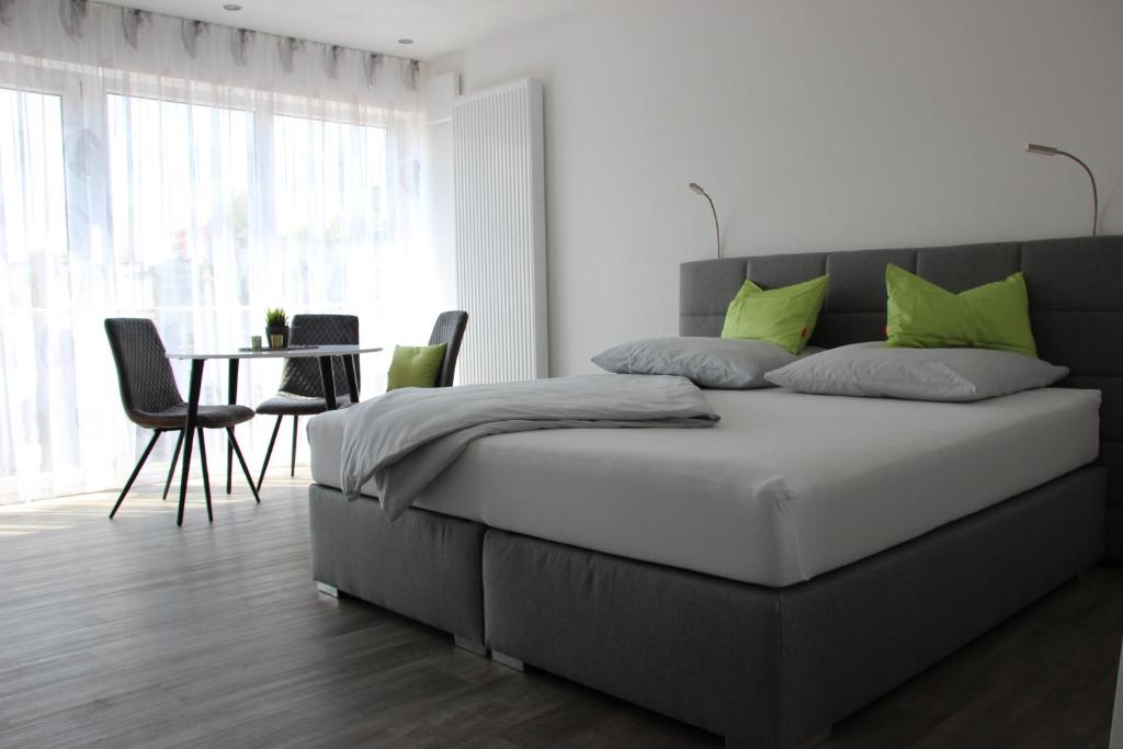 a bedroom with a bed with a table and chairs at Rainer Appartements in Besigheim