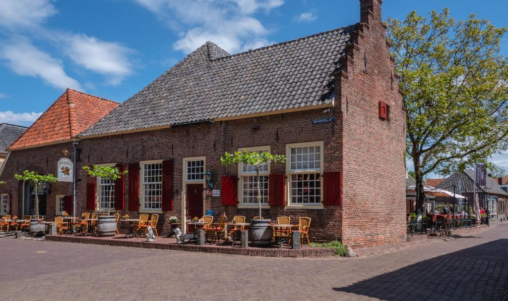 een bakstenen gebouw met tafels en stoelen in een straat bij Herberg de Gouden Leeuw in Bronkhorst