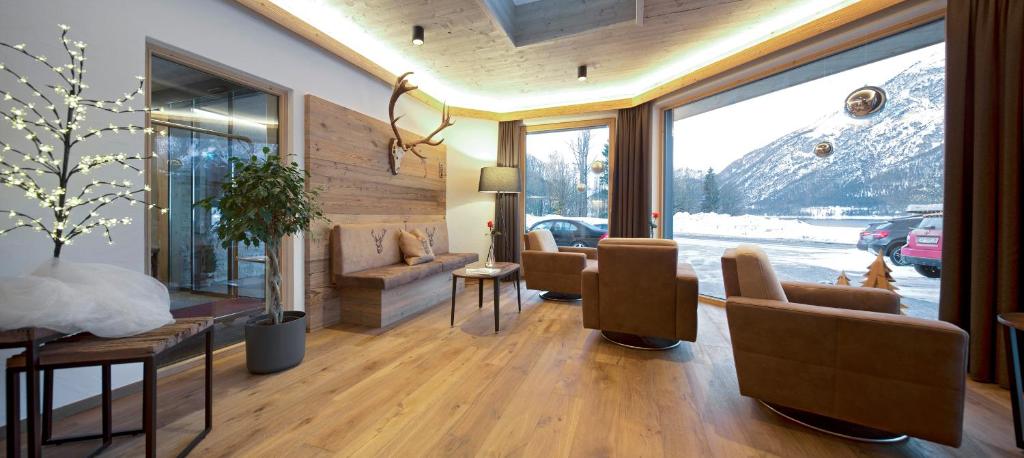 a living room with a view of a snow covered mountain at Hotel Bergland in Pertisau