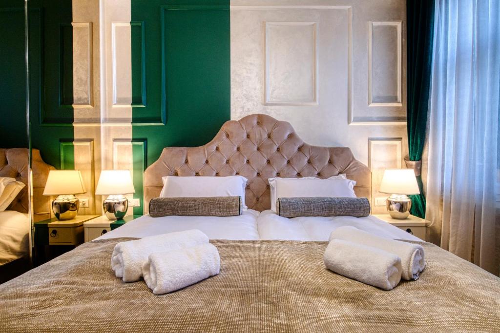 um quarto com uma cama grande com duas almofadas em Riva Palace - design rooms em Zadar