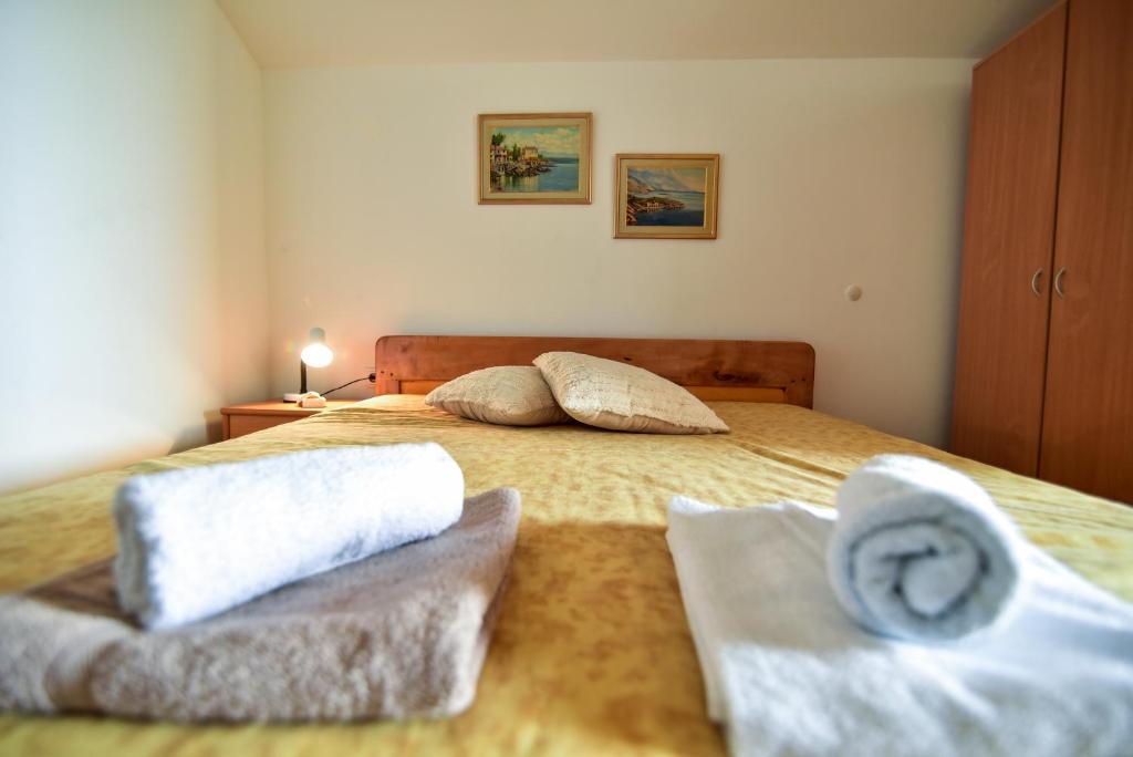 a bedroom with a bed with two towels on it at Nena in Sukošan