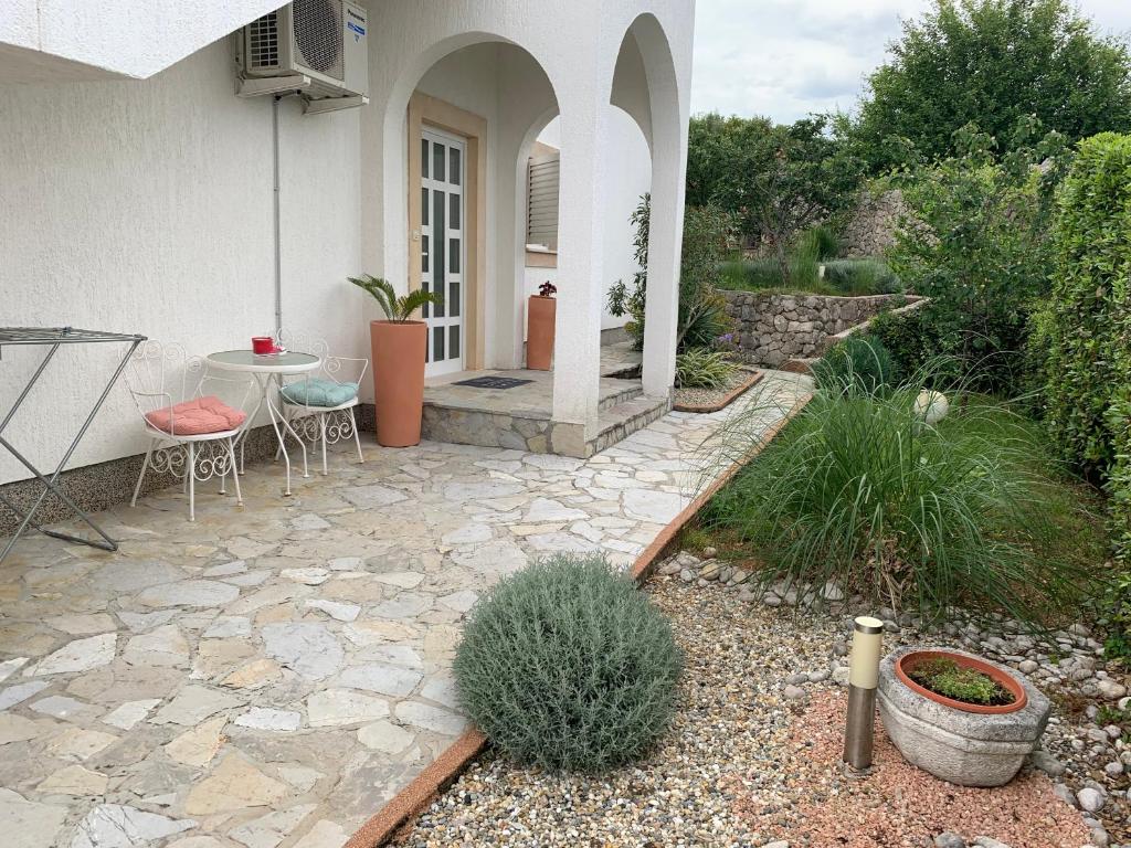 une terrasse d'une maison avec une table et des chaises dans l'établissement Apartman Kartec, à Krk