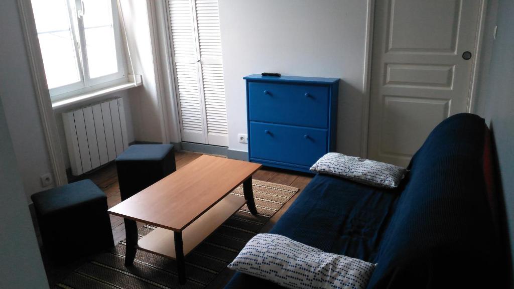 - un salon avec un canapé bleu et une table dans l'établissement Le Petit Bleu - Appt à 5m de la plage, à Dinard