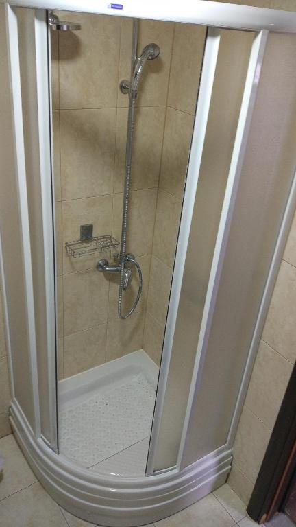 um chuveiro com uma porta de vidro na casa de banho em Kuća u prirodi em Divčibare