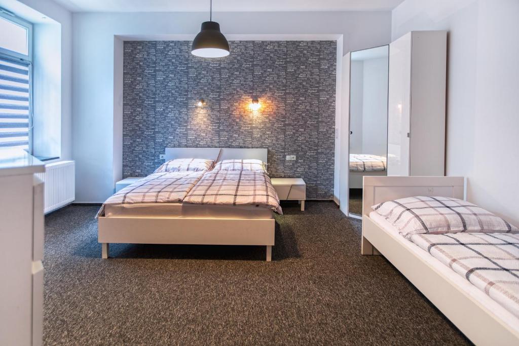 a bedroom with two beds and a brick wall at Apartamenty Jana in Katowice