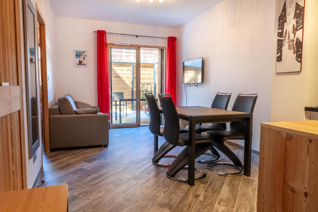 uma sala de estar com uma mesa de jantar e cadeiras em PORTES DU PLENEY 001 em Morzine