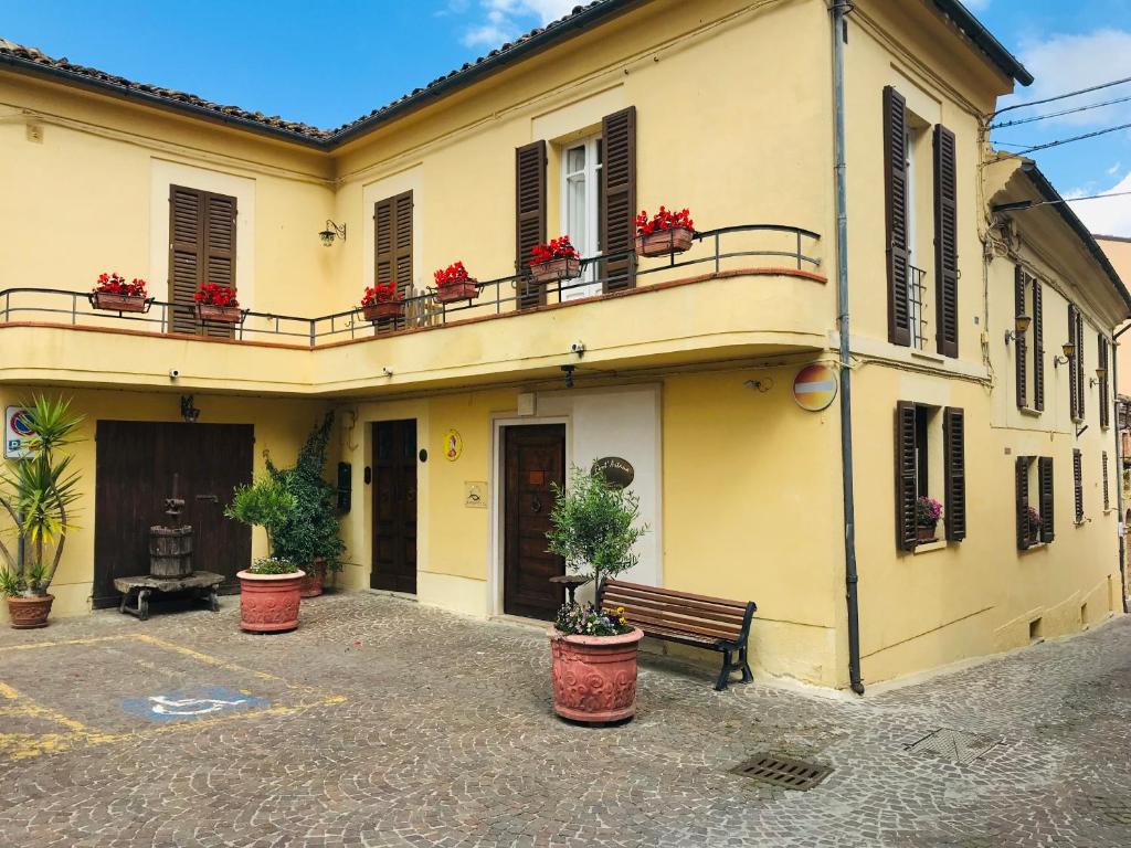 ein Gebäude mit Blumentöpfen und einer Bank davor in der Unterkunft Don Pasquale Picciano- PESCARA-ABRUZZO in Picciano