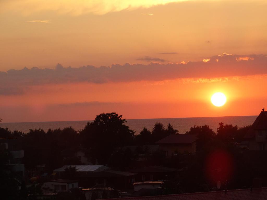 a sunset view of the ocean and a city at Apartament z widokiem na morze - Apartament Turkusowy in Sianozety