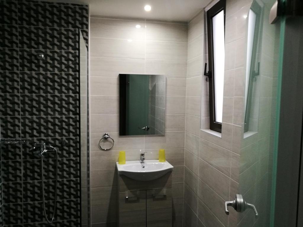 a bathroom with a sink and a mirror at Golden days in Afantou