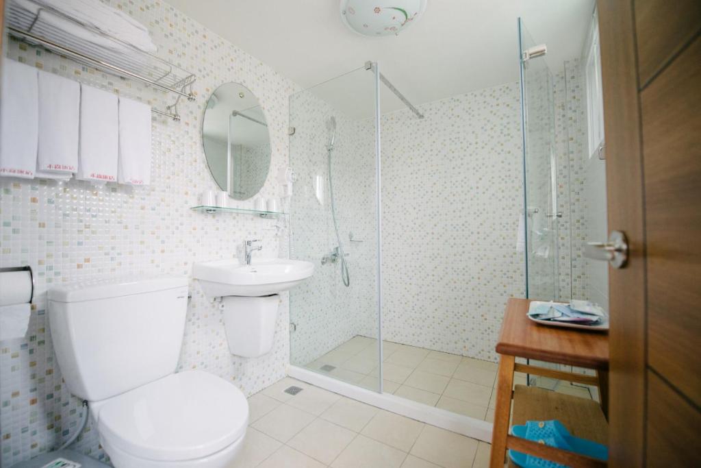 a bathroom with a toilet and a sink and a shower at He Sen B&B in Kenting