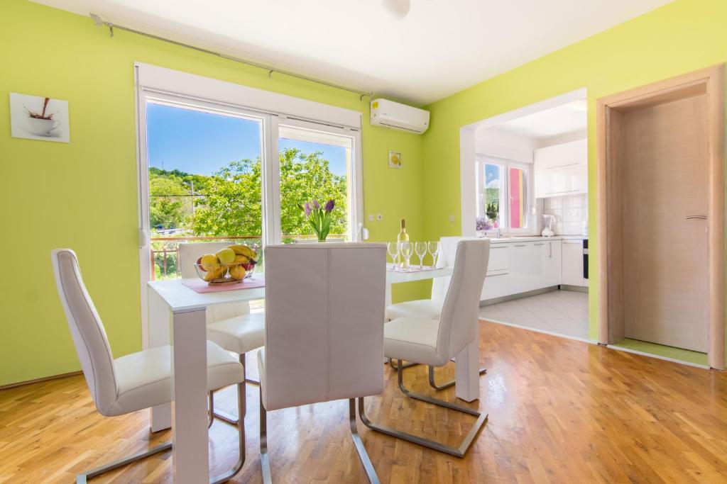 a kitchen and dining room with green walls and a table and chairs at Apartman Vendi in Zagvozd