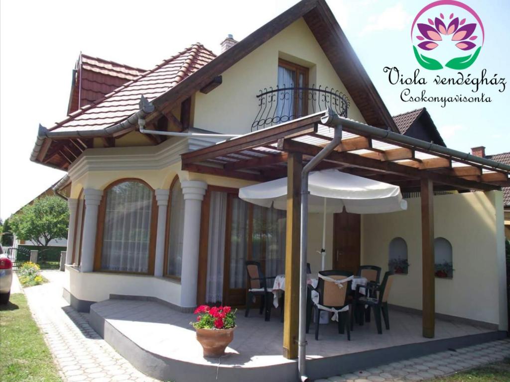 a house with a table and chairs in front of it at Viola vendégház in Csokonyavisonta