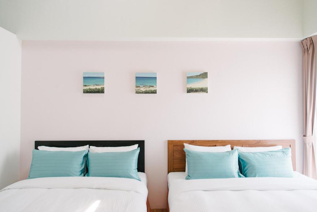 two beds sitting next to each other in a bedroom at He Sen B&B in Kenting