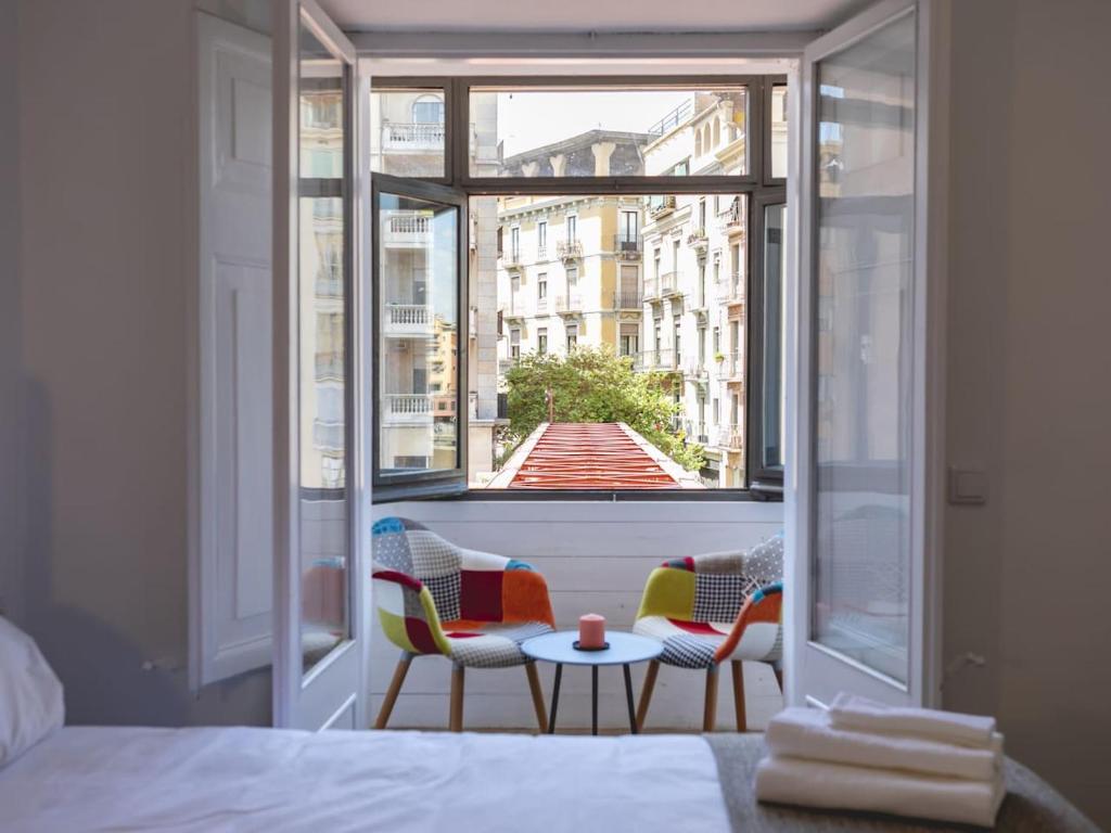 a bedroom with a window with chairs and a table at Bravissimo Rambla Eiffel Bridge 2 in Girona