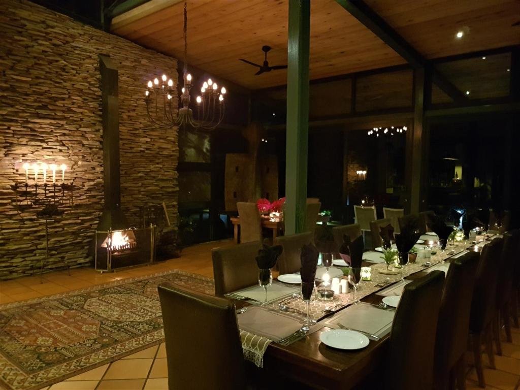 a long dining table in a room with a fireplace at Greenfire Game Lodge in Balule Game Reserve