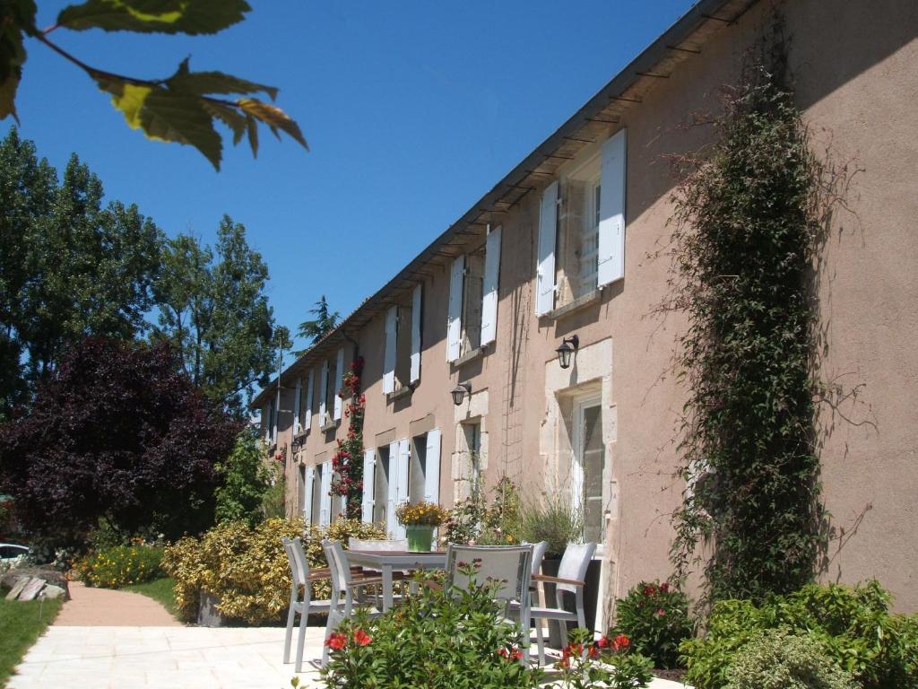 a building with tables and chairs outside of it at Chambres d'hôtes La Charrière in Cheffois