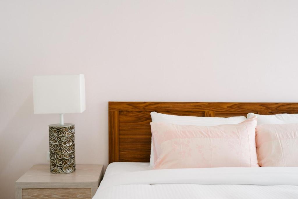 a bedroom with a bed with a wooden headboard and a lamp at He Sen B&B in Kenting