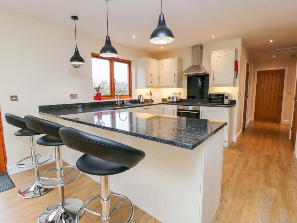 a kitchen with a large island with bar stools at Oak Lodge in York